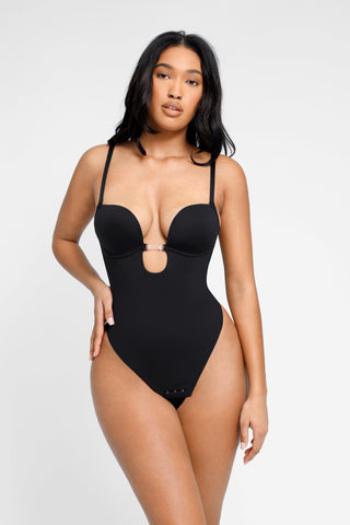 A model wearing a black Bombshell Invisible Bra Bodysuit with a deep V-neckline and spaghetti straps.