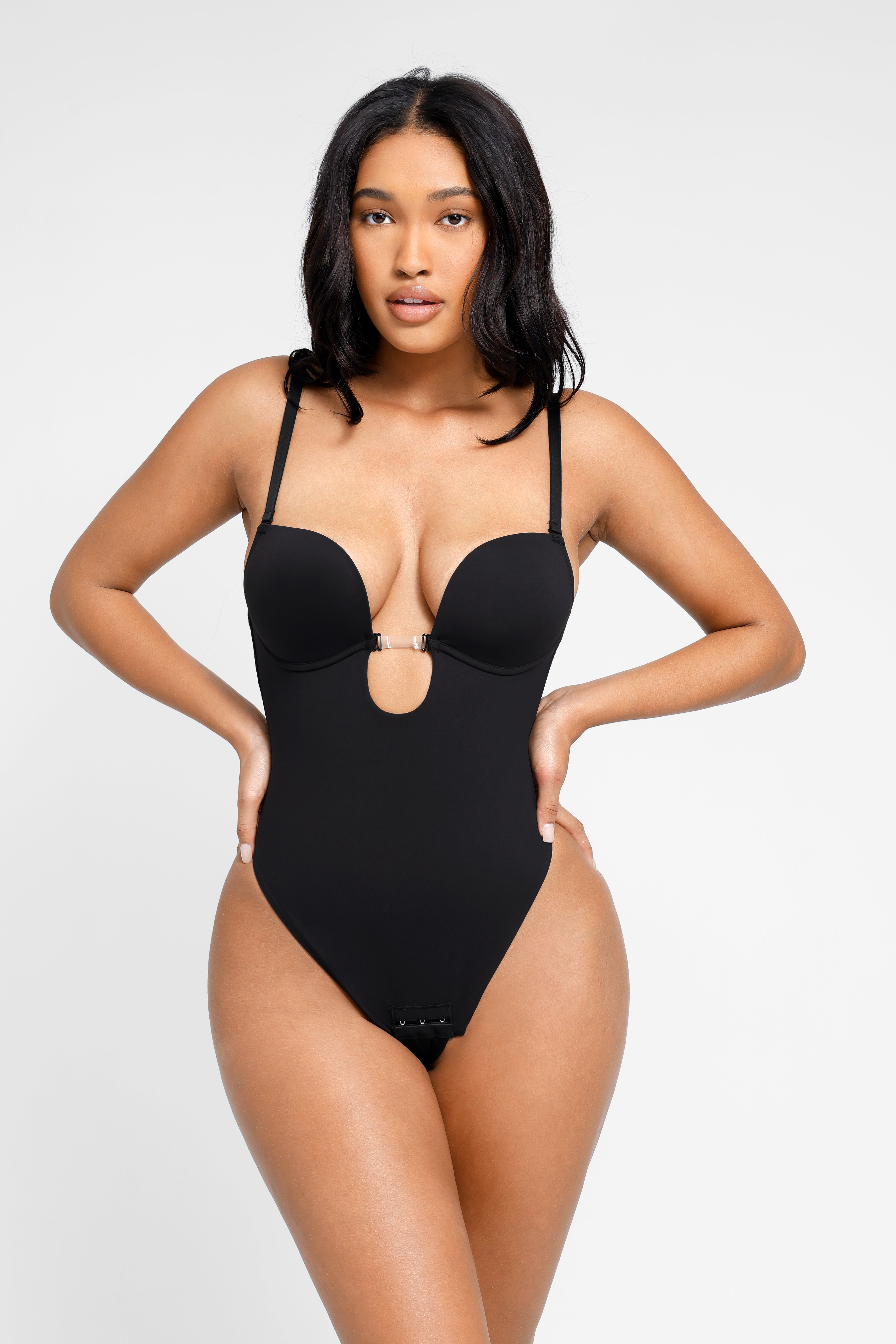 Woman wearing a black bra bodysuit on a white background